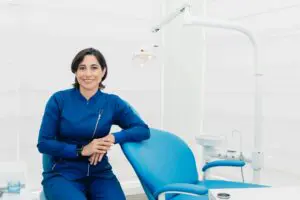 Photo by iam luisao: https://www.pexels.com/photo/woman-in-blue-attire-sitting-beside-dental-chair-12917343/ friendly dental professional