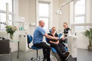 https://pixabay.com/photos/all-on-4-dental-implants-belfast-8378579/ Patient looking at new teeth in a mirror